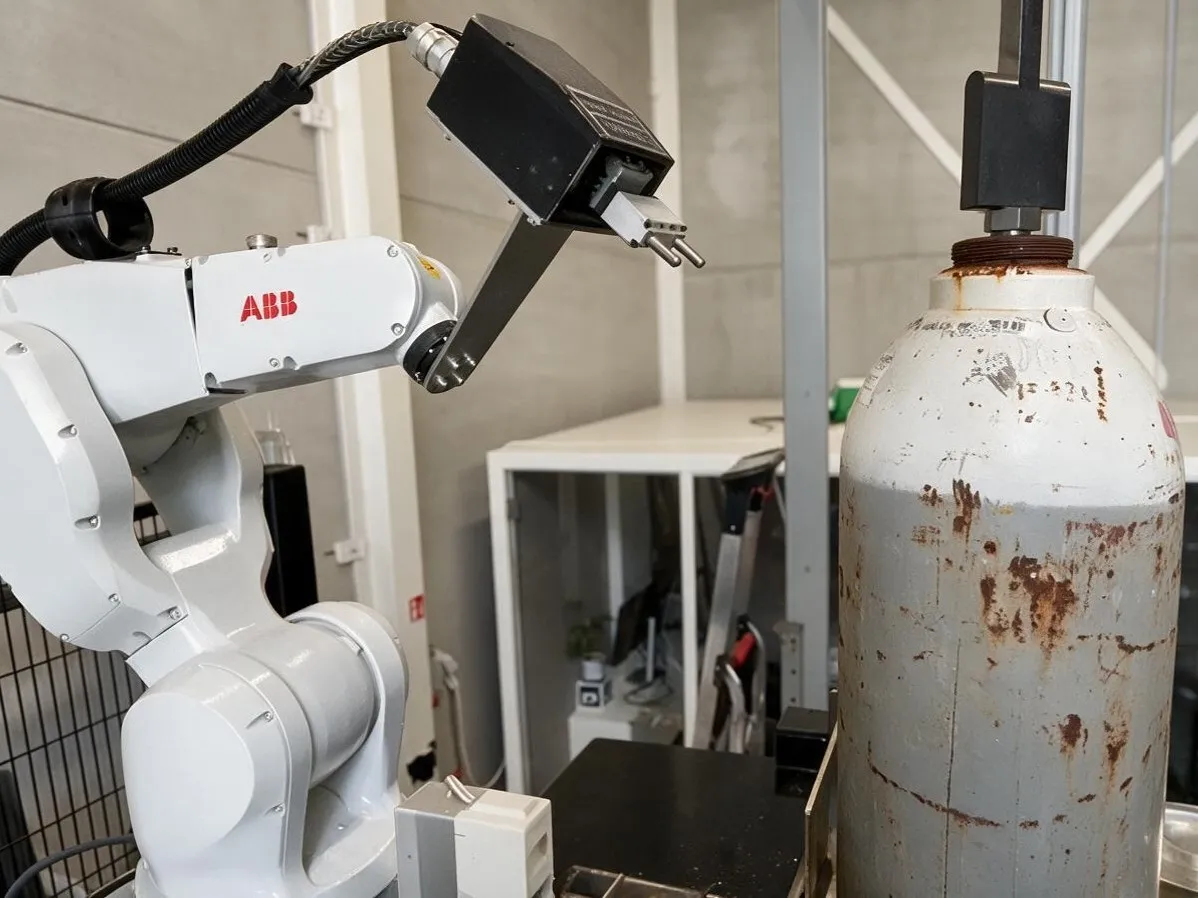 Robot graveert een gasfles met een pneumatisch graveergereedschap